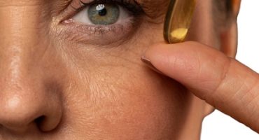 Portrait of senior woman with fish oil pill for skincare