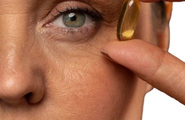 Portrait of senior woman with fish oil pill for skincare