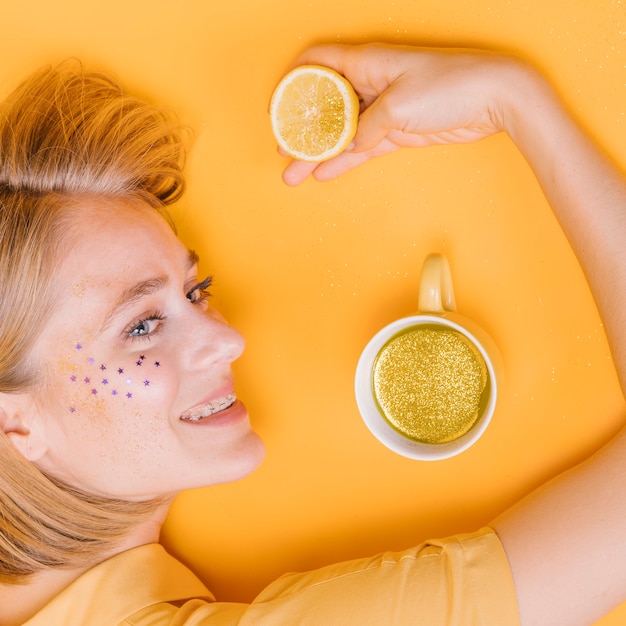 Top view of woman with cup and lemonade in yellow scene